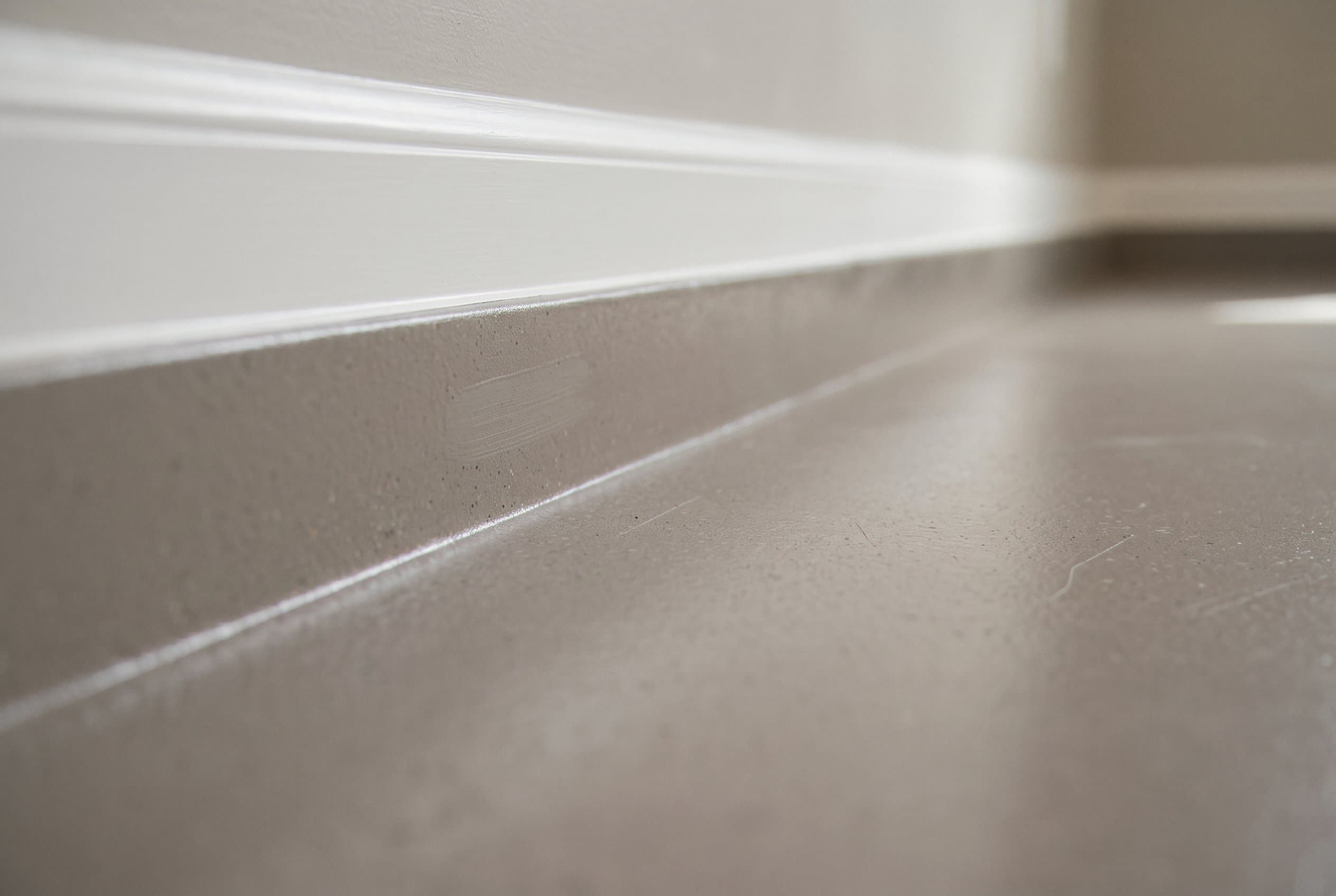 Coved edge where epoxy meets a basement wall.